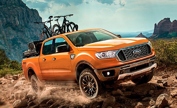 Ford Ranger 2019 color Blue Lightning con rack personalizado para bicicletas subiendo montaña.